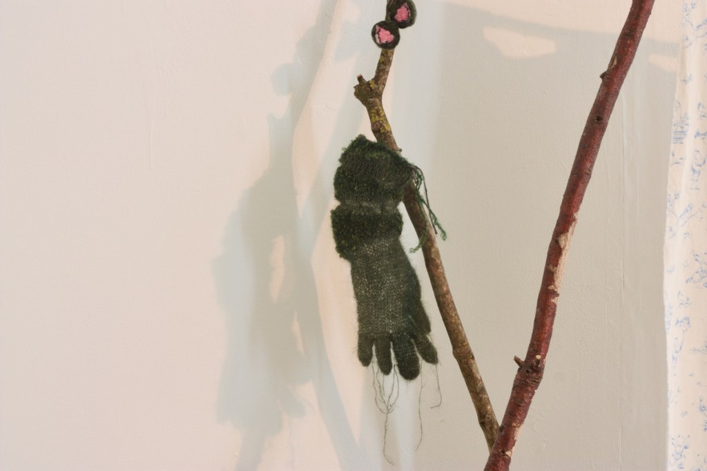 detail of knitted glove / hand made of floaty dark green mohair