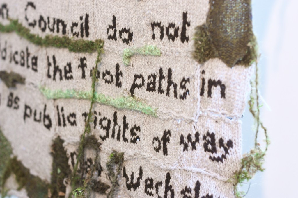 detail of knitted Croydon council sign:'Council do not ... dicate the foot paths in... as public rights of way ... David Wechsler.'